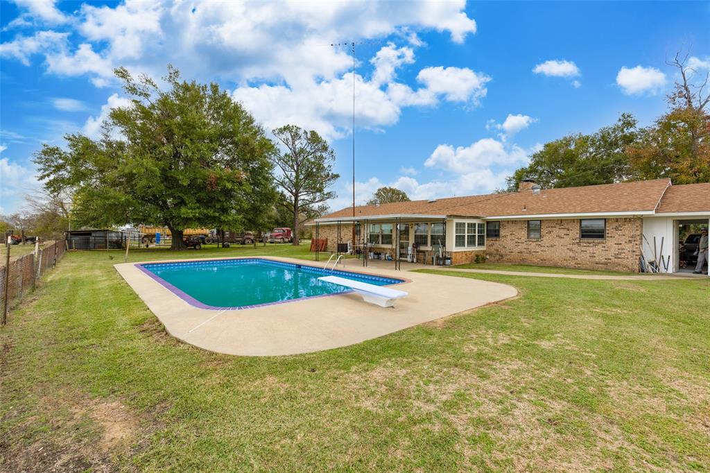 a view of a house with swimming pool and yard