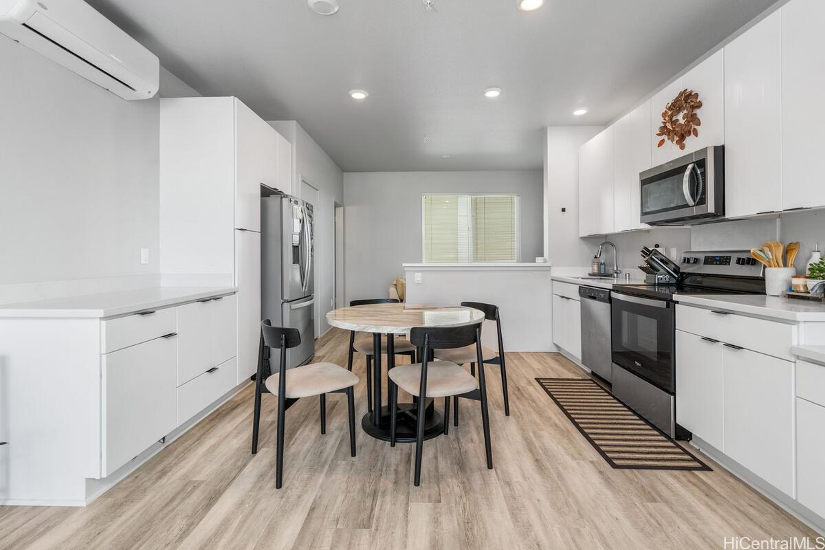 a kitchen with a table chairs a sink dishwasher stove and cabinets with wooden floor