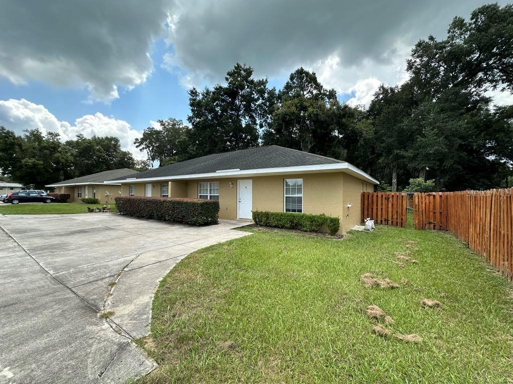 a front view of house with yard and trees in the background