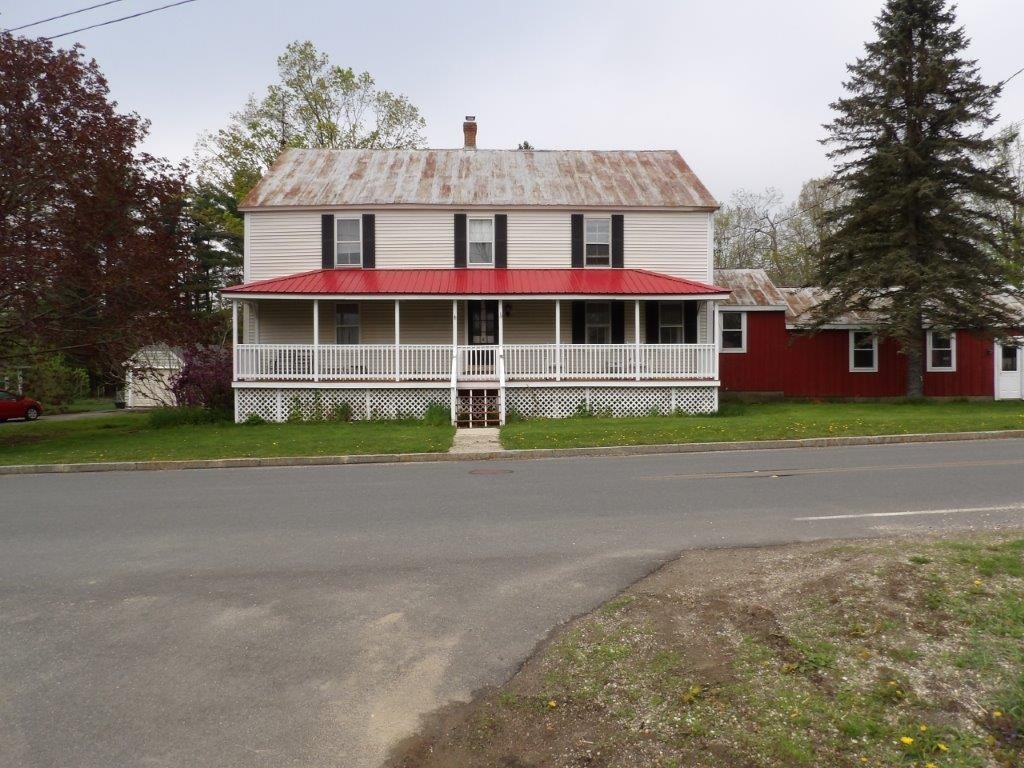 a front view of a house with a garden and trees