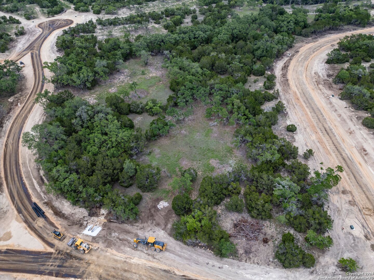 an aerial view of a house with a yard and greenery