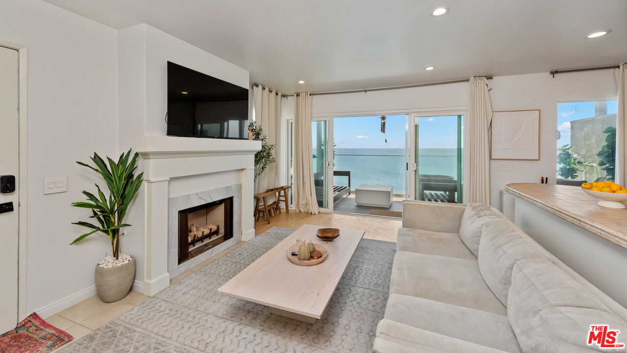 a living room with furniture fireplace and a large window