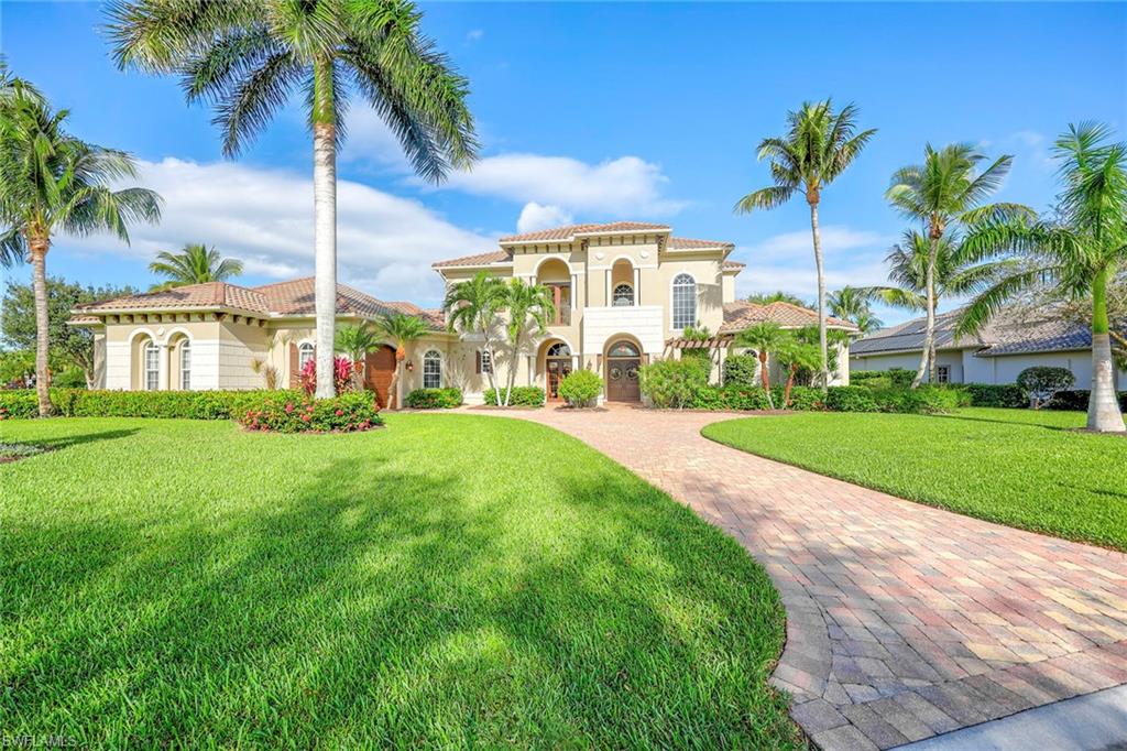 a view of a house with a big yard and palm trees