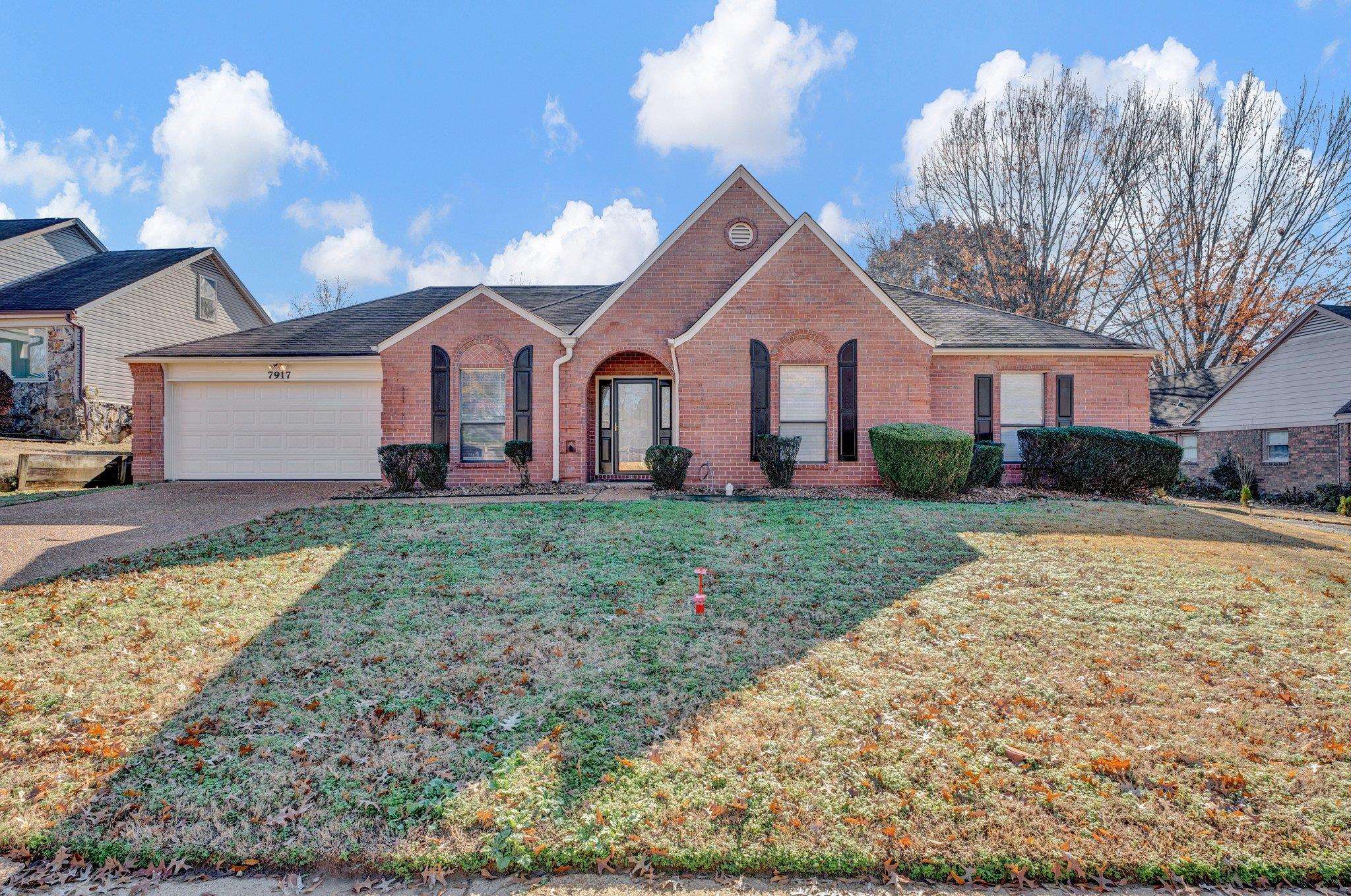 View of front of property featuring a front yard and a garage