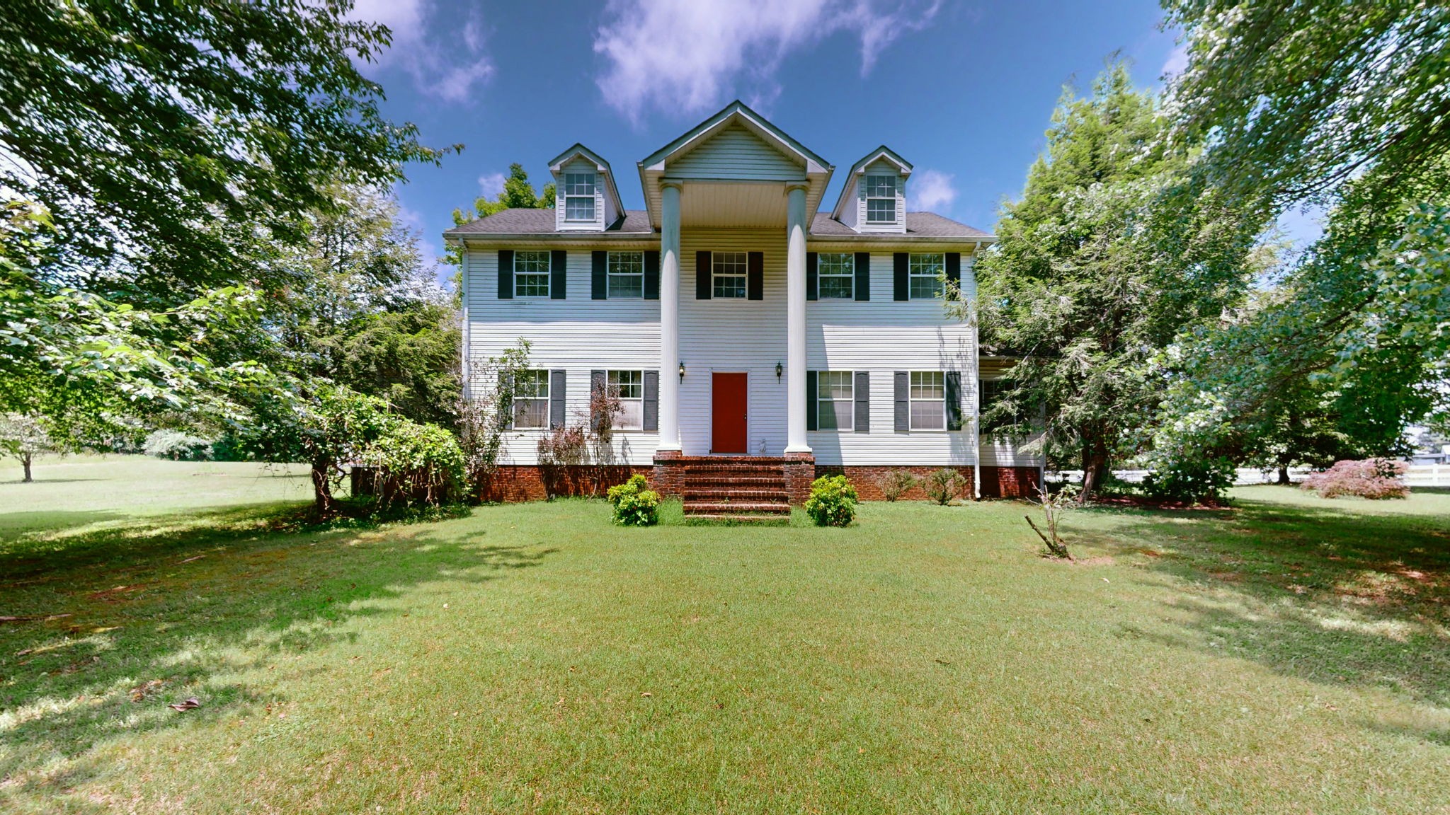 a front view of house with yard and green space