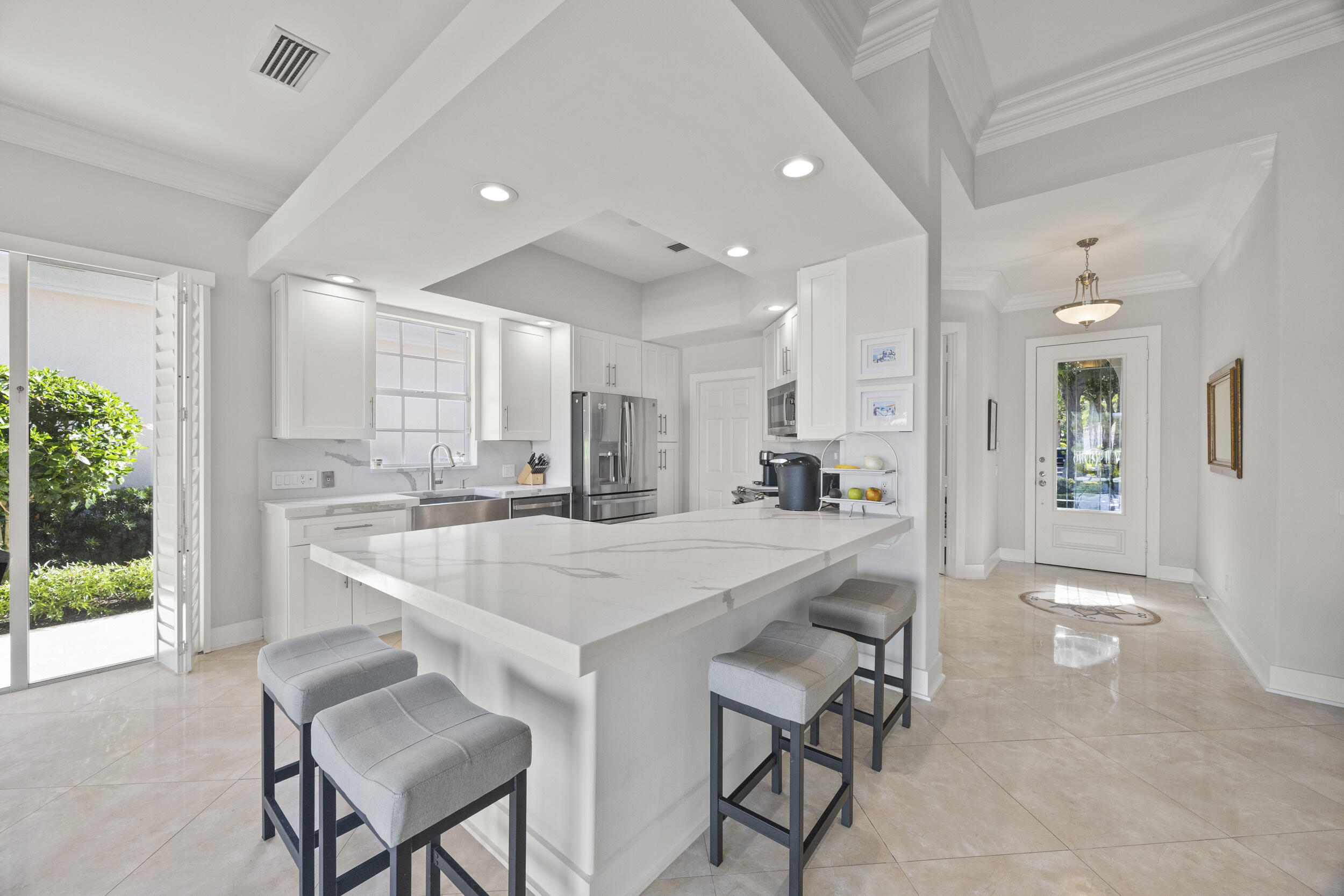 a large white kitchen with a table and chairs