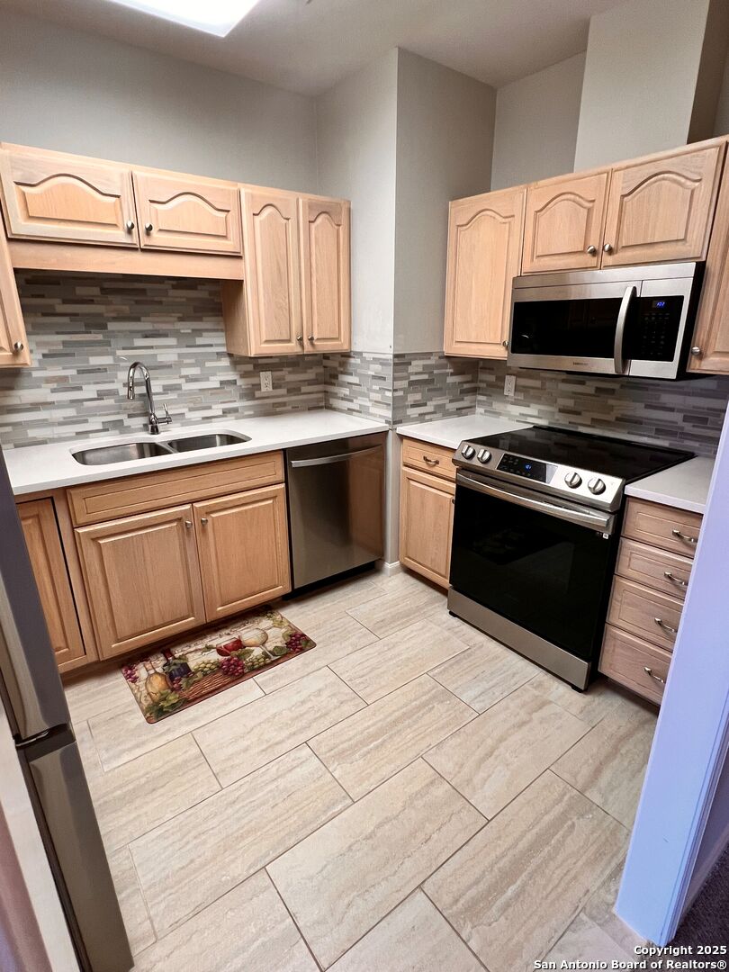 a kitchen with stainless steel appliances granite countertop a sink stove and cabinets