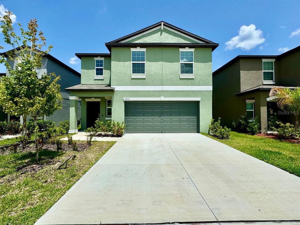 a front view of a house with yard and green space