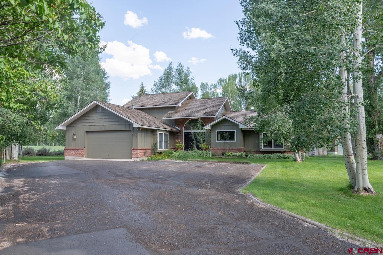 a front view of a house with a yard and trees