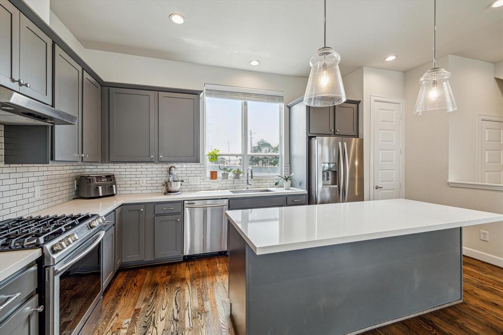 a kitchen with stainless steel appliances a sink stove and refrigerator