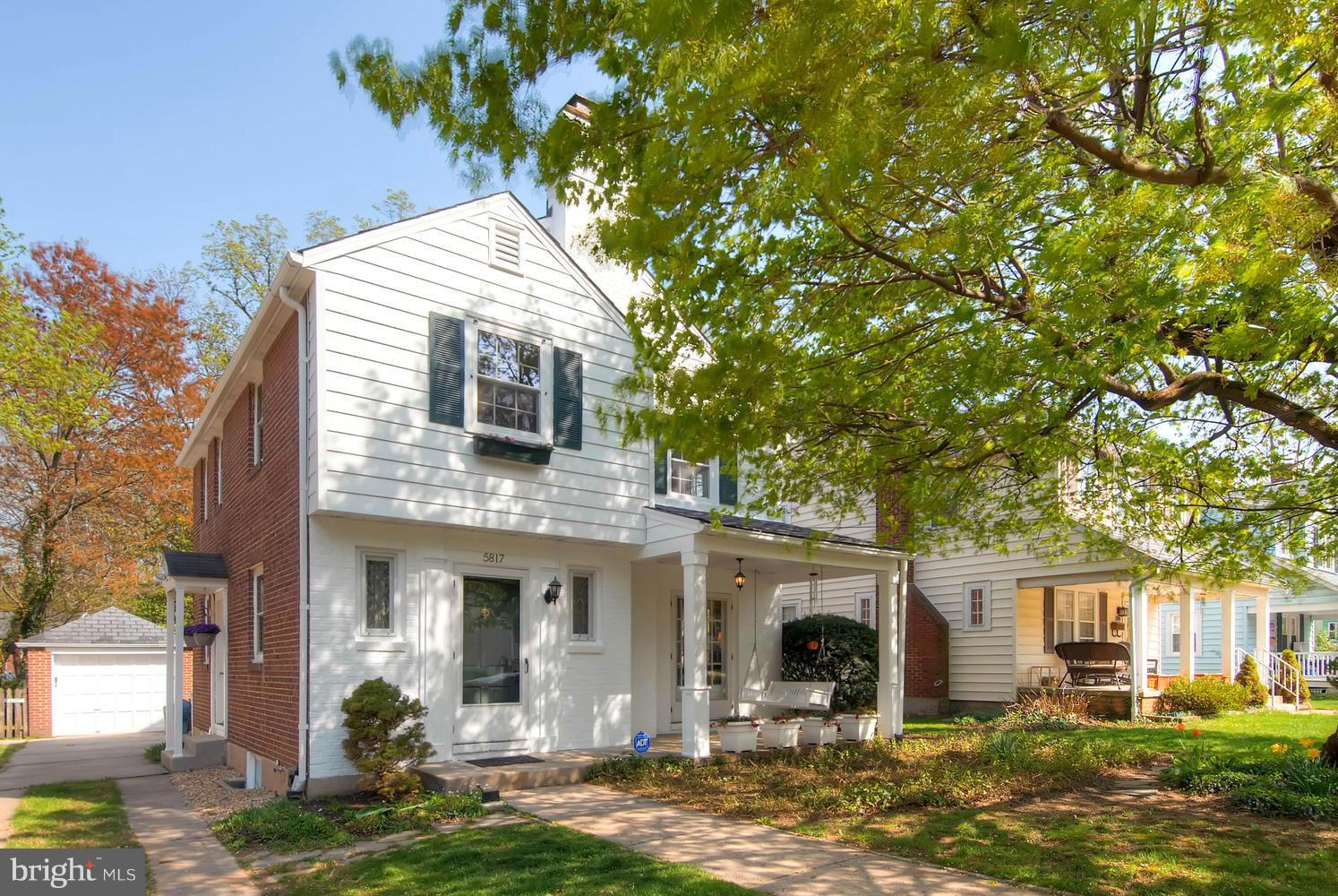 a front view of house with yard and trees in the background