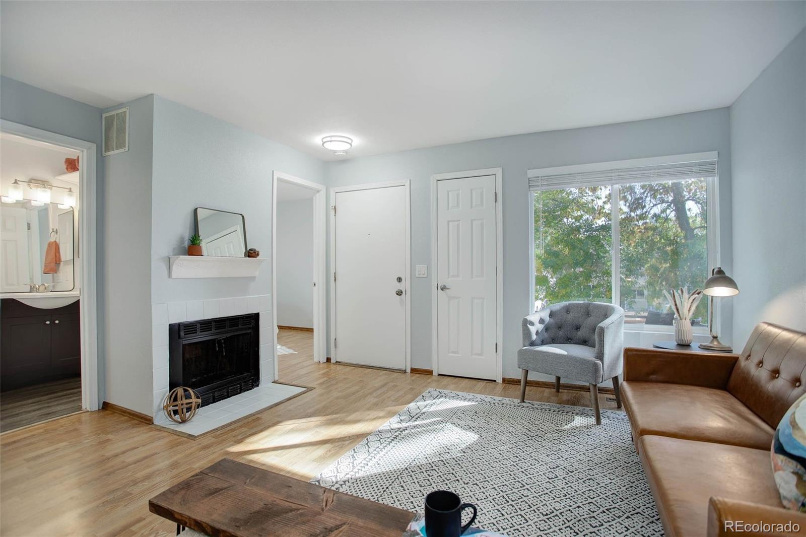 a living room with furniture a fireplace and a floor to ceiling window