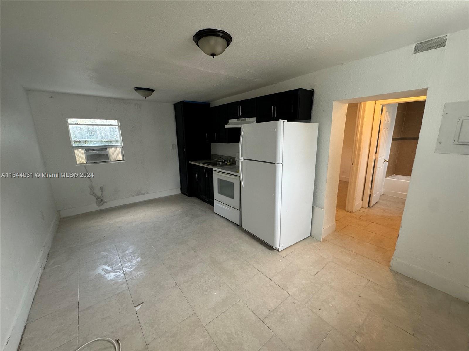 a view of kitchen with refrigerator and window