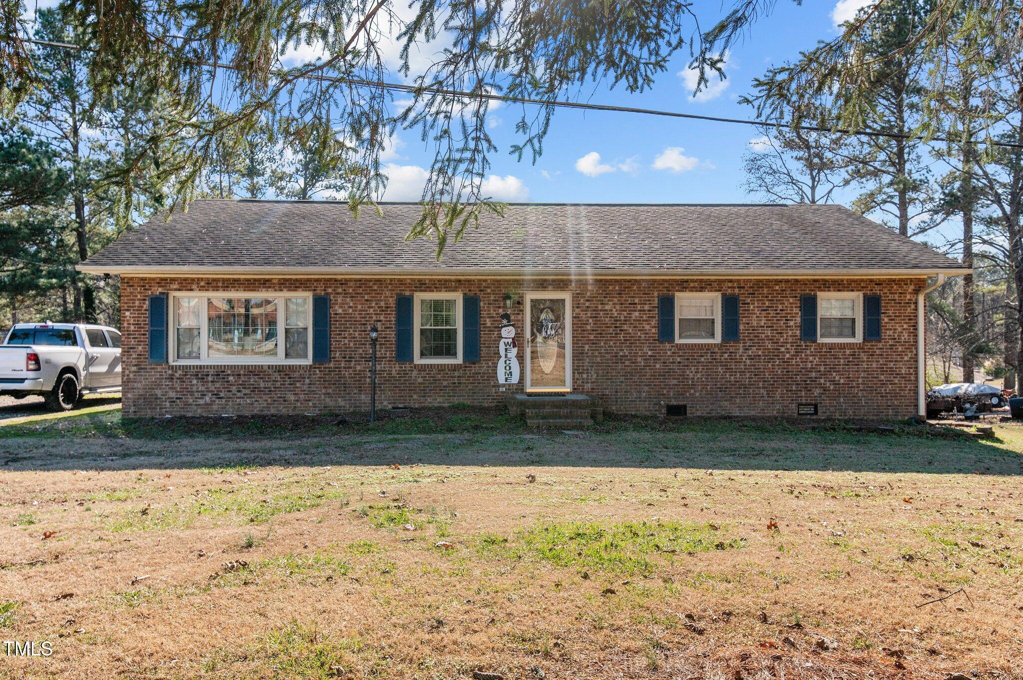 a view of house with yard and a tree