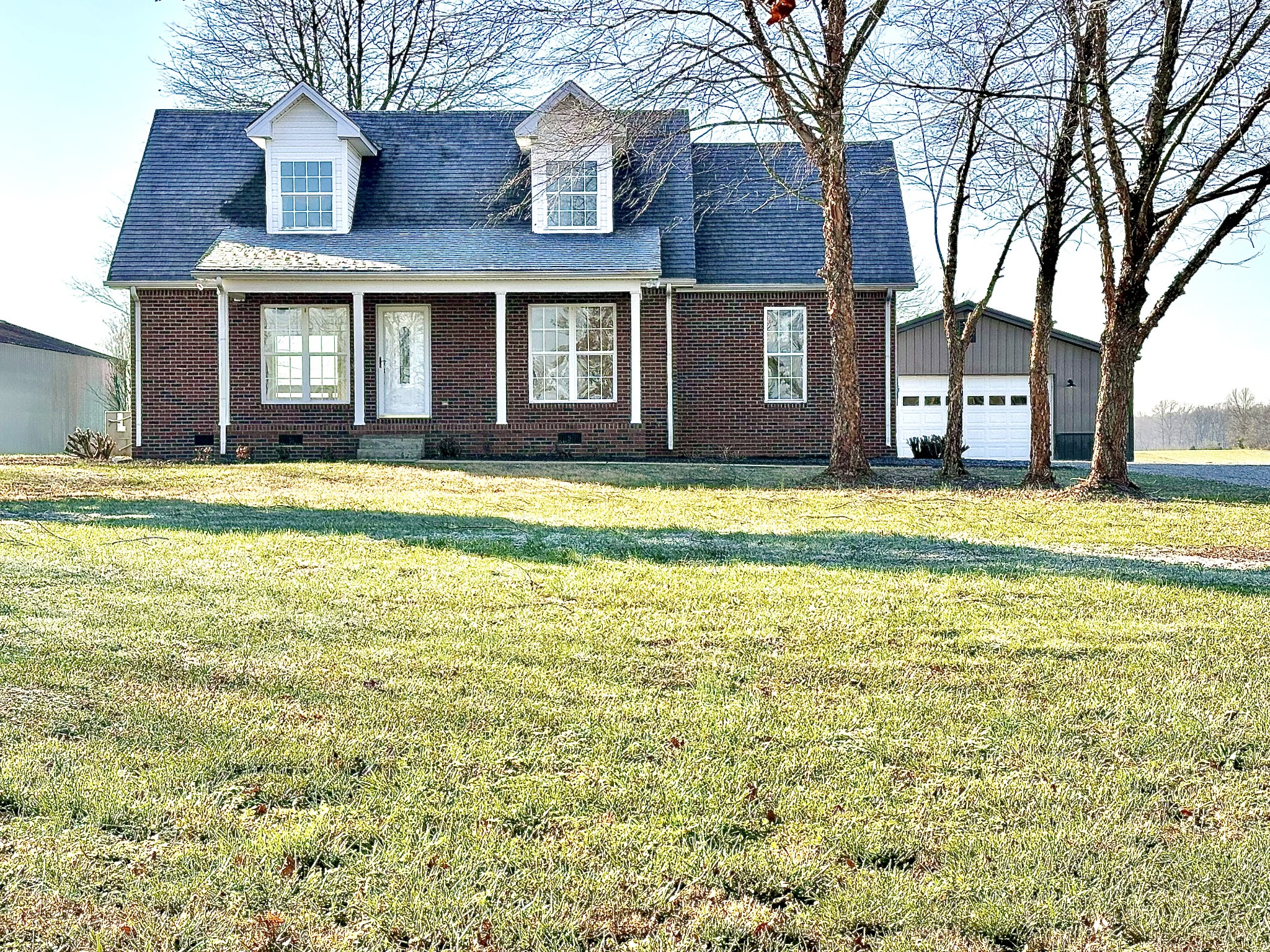 a view of a brick house with a large trees