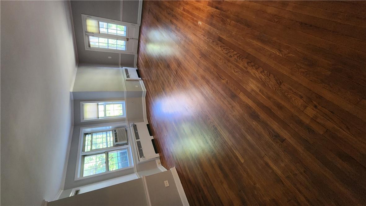 Spare room with ornamental molding, radiator, an AC wall unit, and dark wood-type flooring