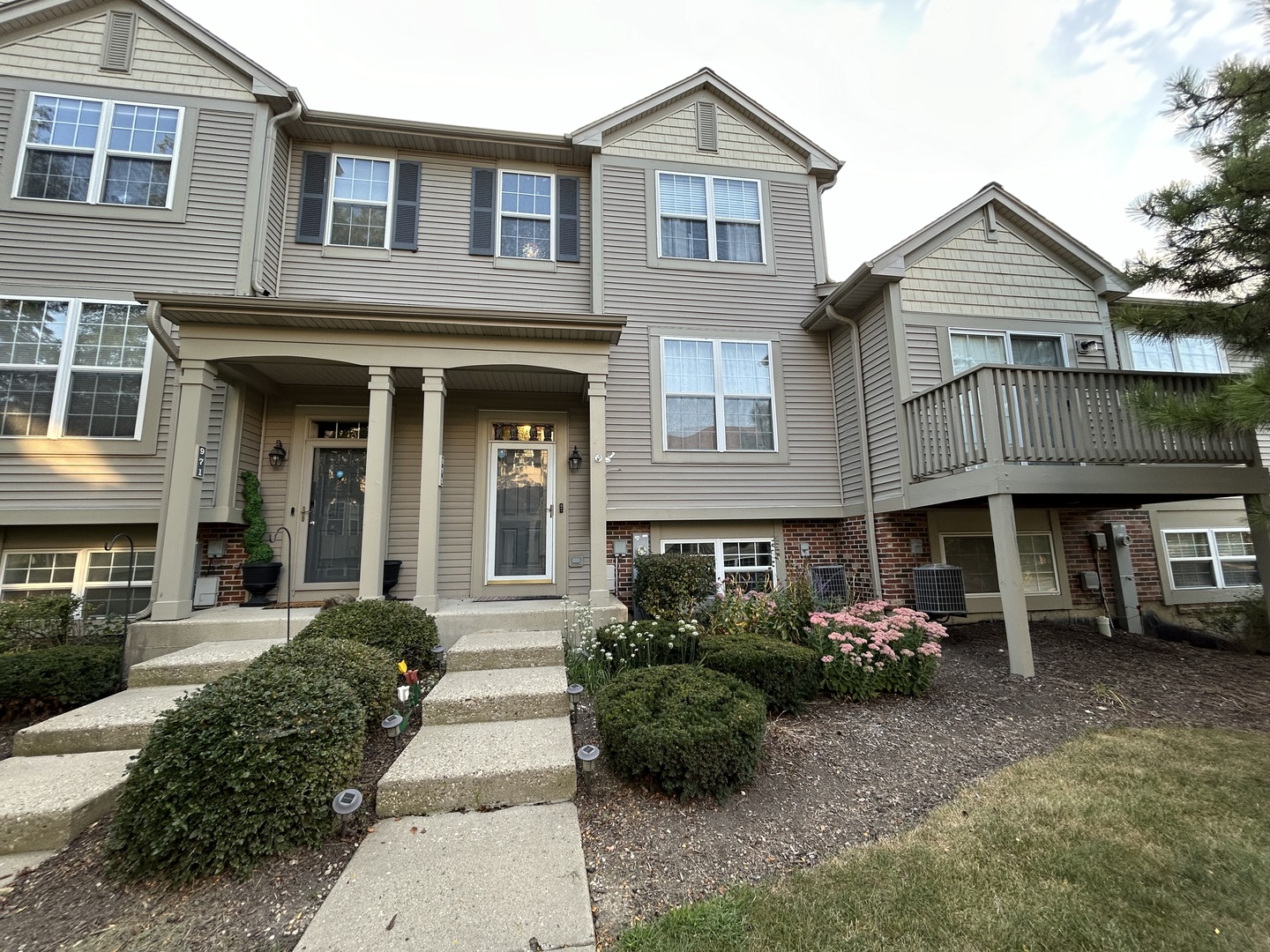 a front view of a house with a garden and plants