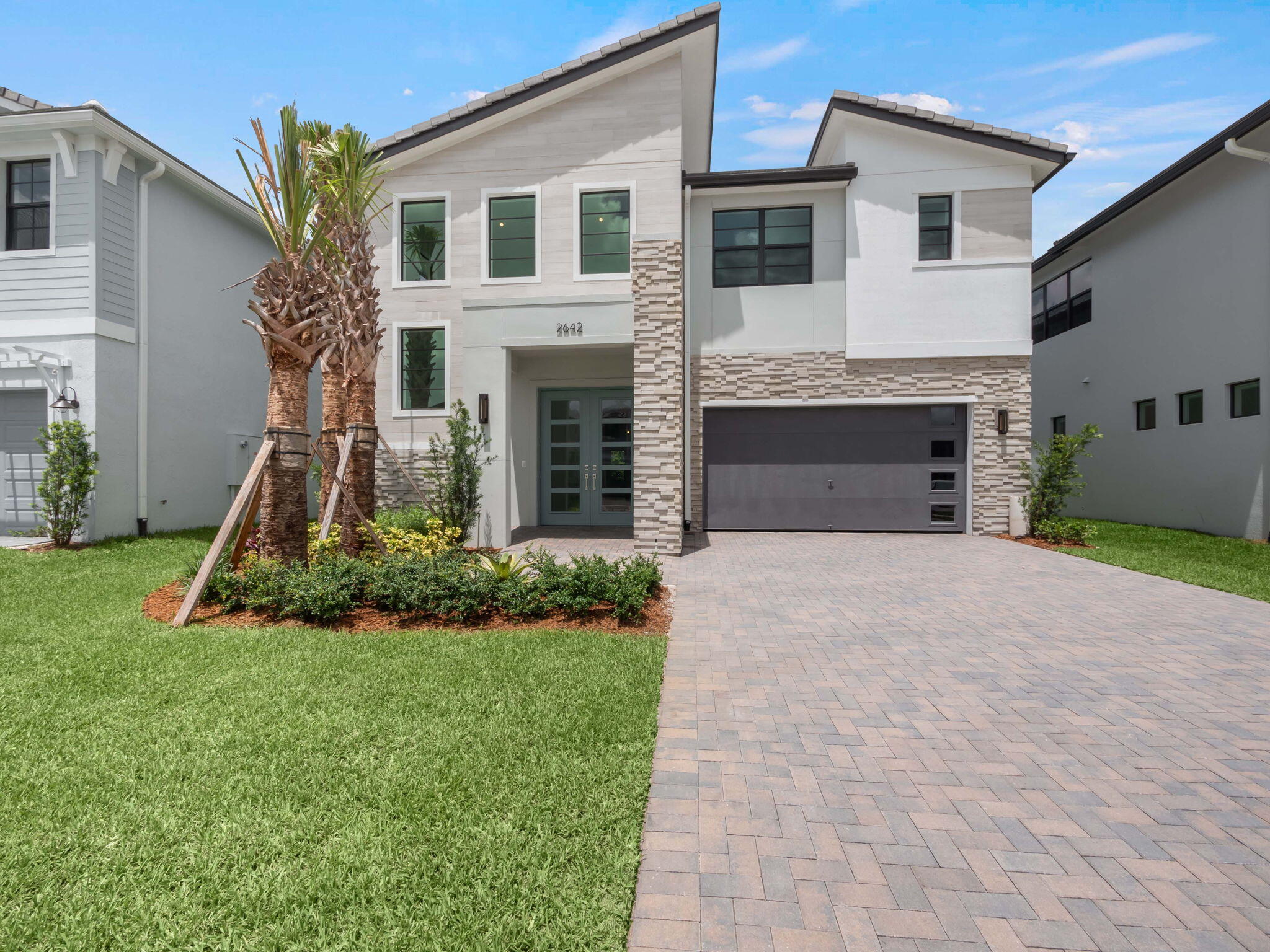 a front view of a house with a yard and garage