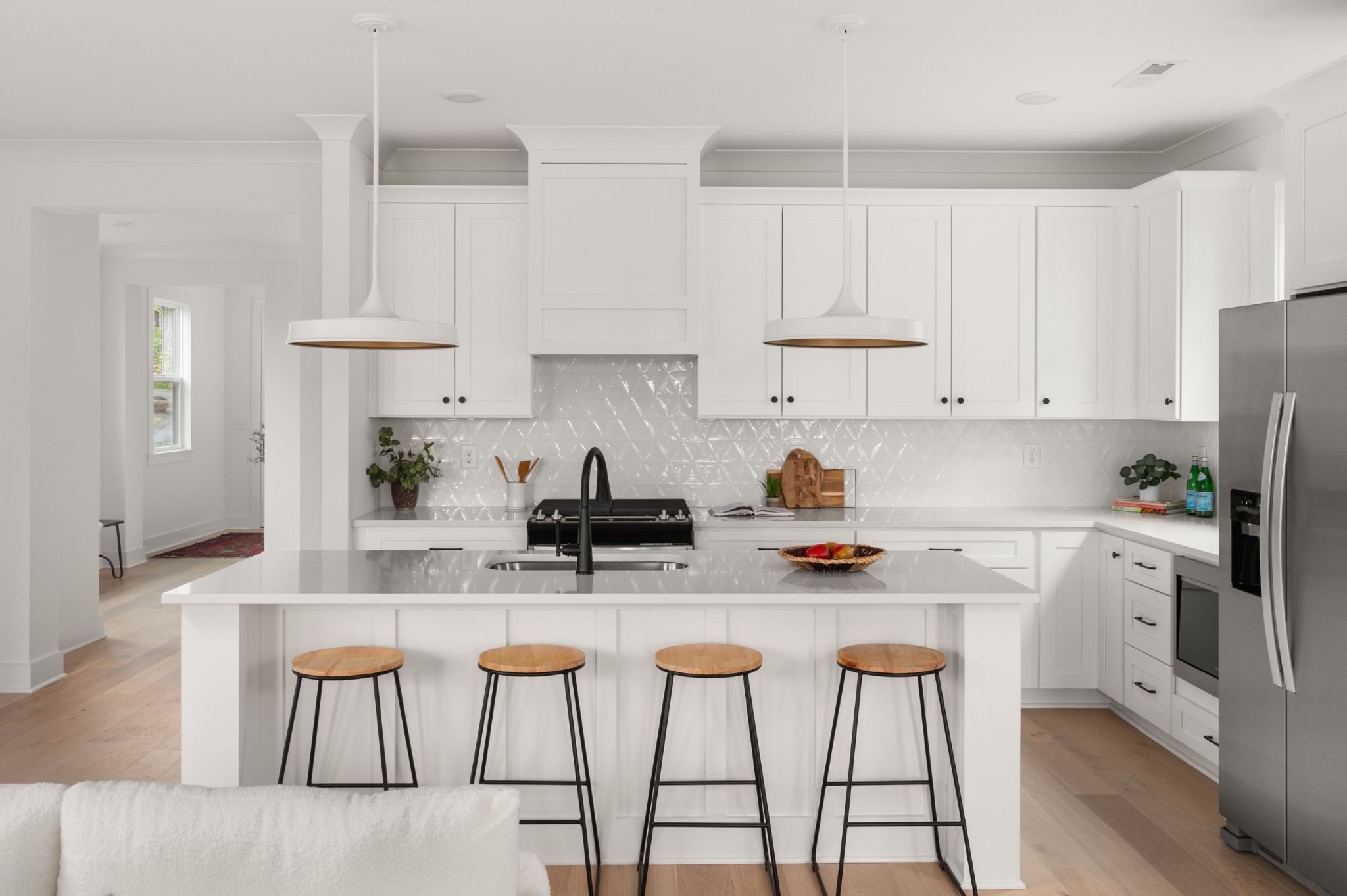 a kitchen with stainless steel appliances a stove a sink and white cabinets