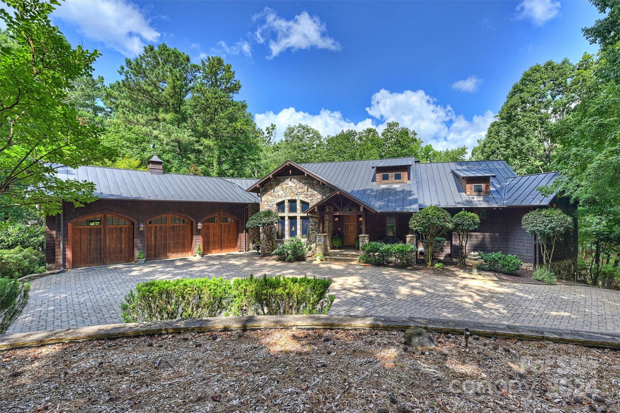 a front view of a house with a yard and a tree