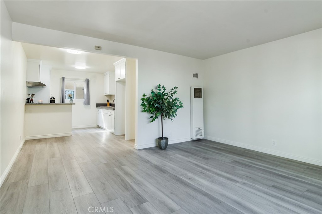 a view of a kitchen with wooden floor and a potted plant