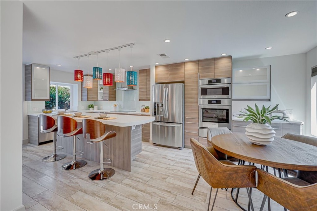 a kitchen with stainless steel appliances a dining table chairs and granite counter tops