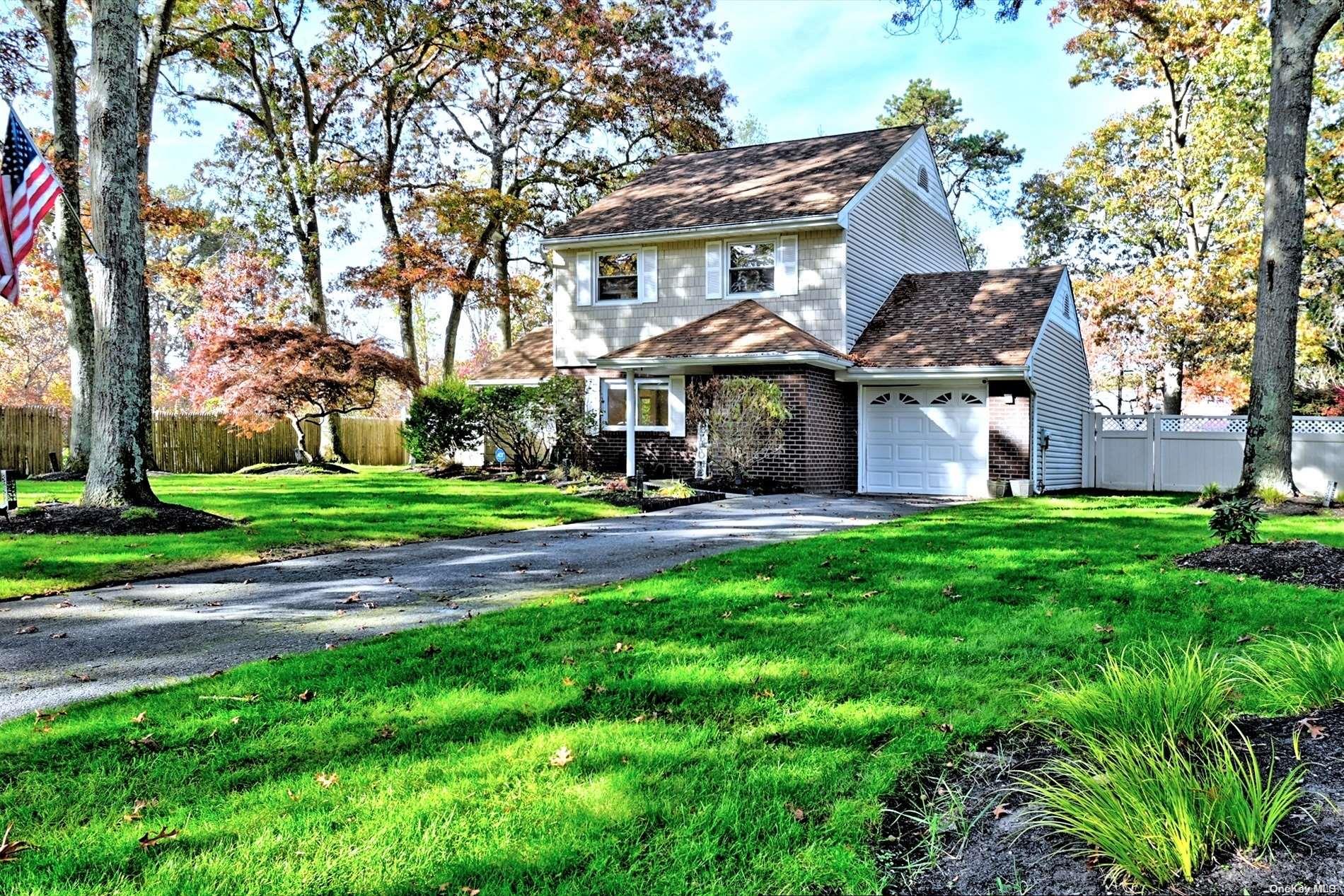 a front view of a house with yard and green space