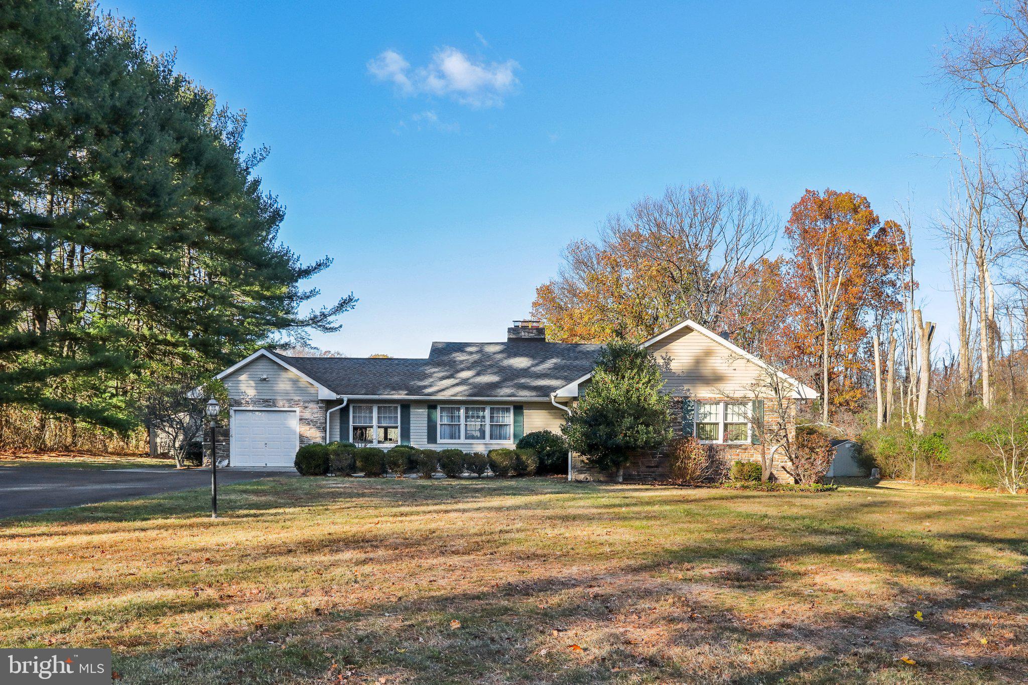 a front view of a house with a big yard and large trees