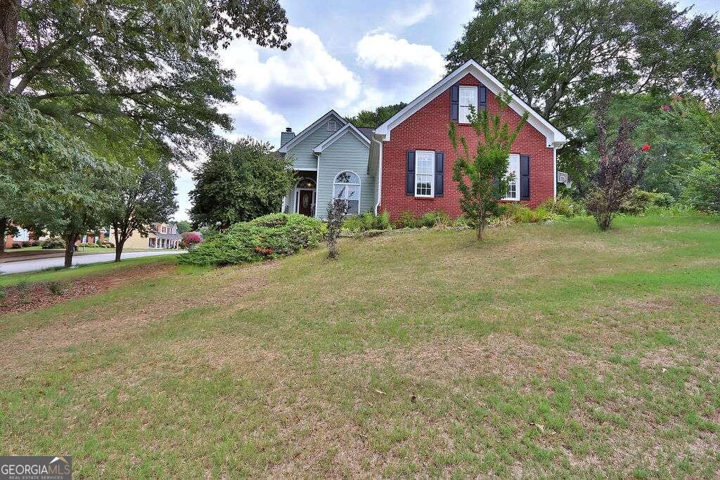 a view of a house with a yard and tree s