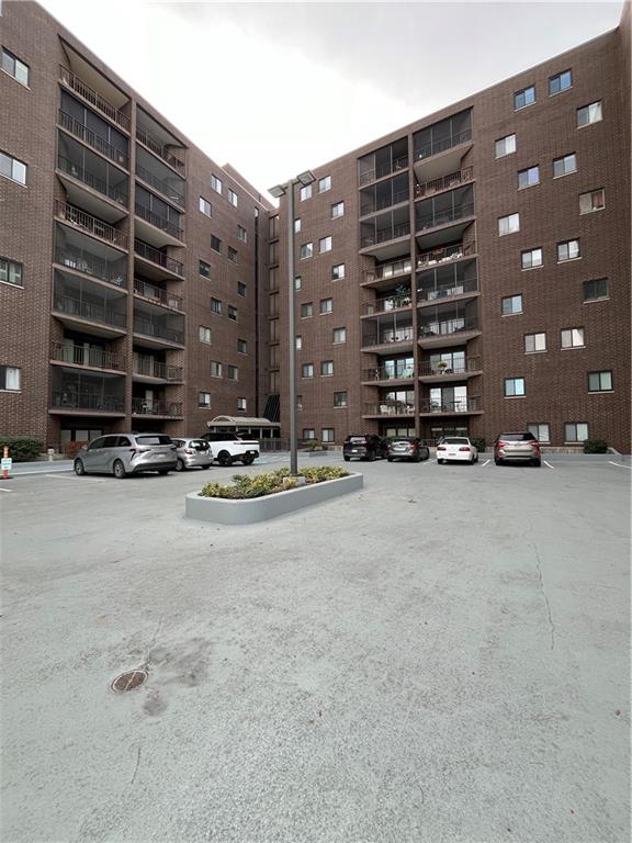 a view of the building with cars parked in front of it