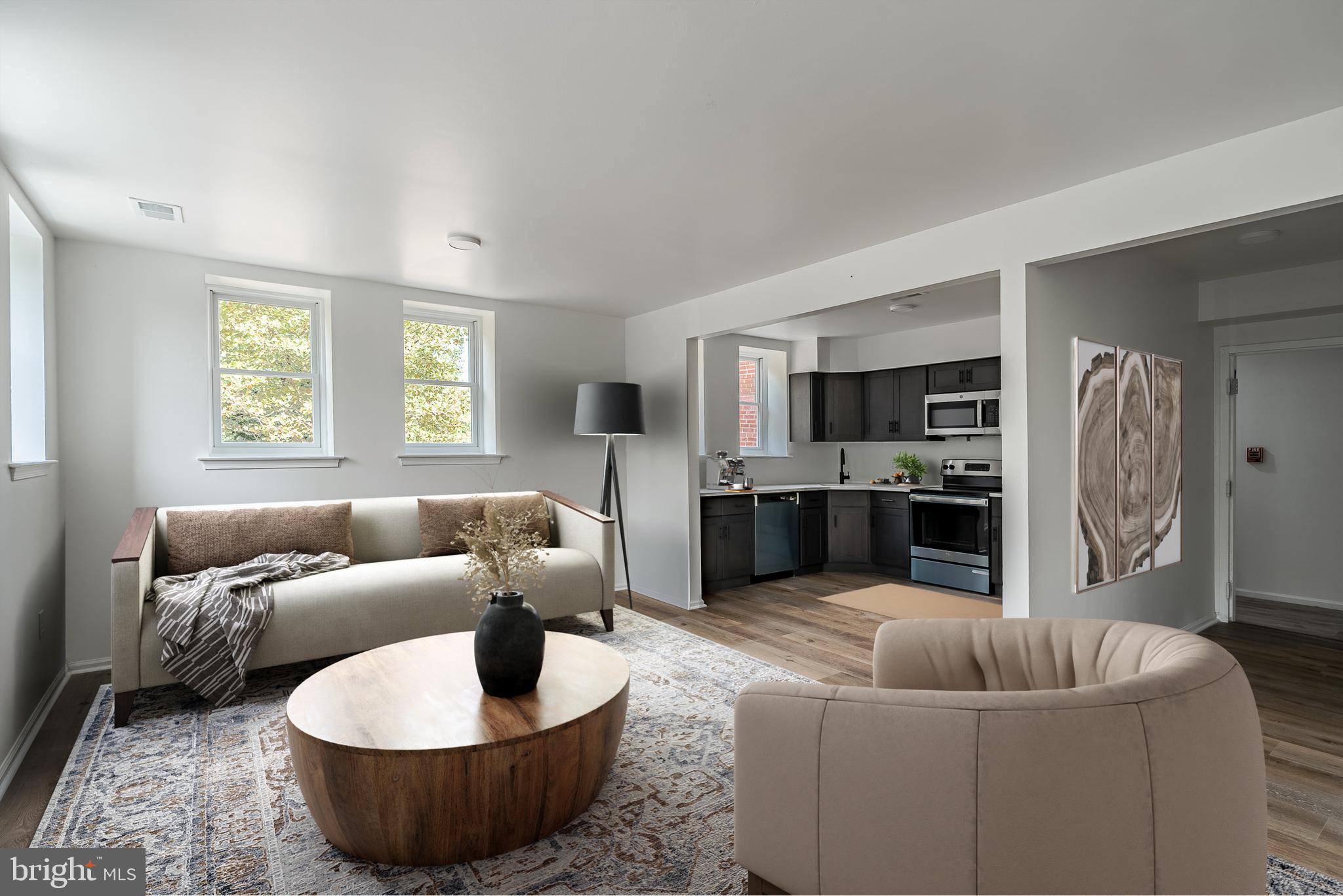 a living room with furniture and a view of kitchen