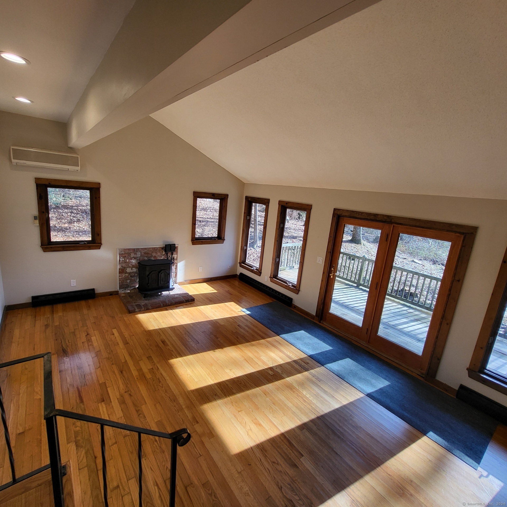 a living room with furniture floor to ceiling window and a wooden floor