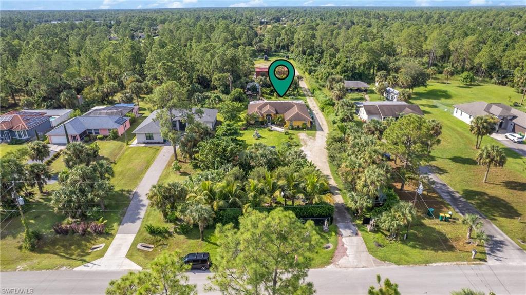 an aerial view of residential house with outdoor space and trees all around