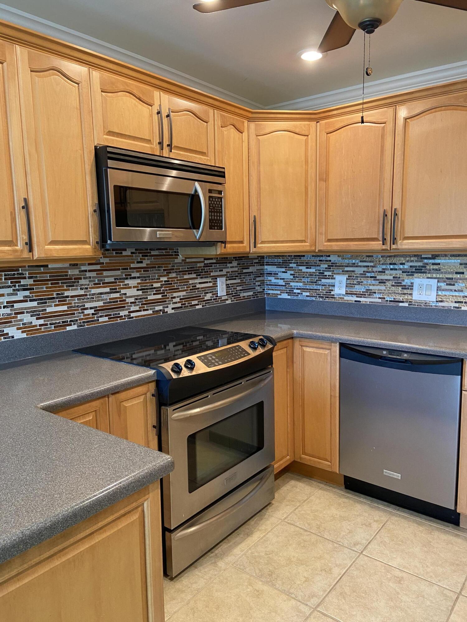 a kitchen with granite countertop a stove top oven microwave and cabinets