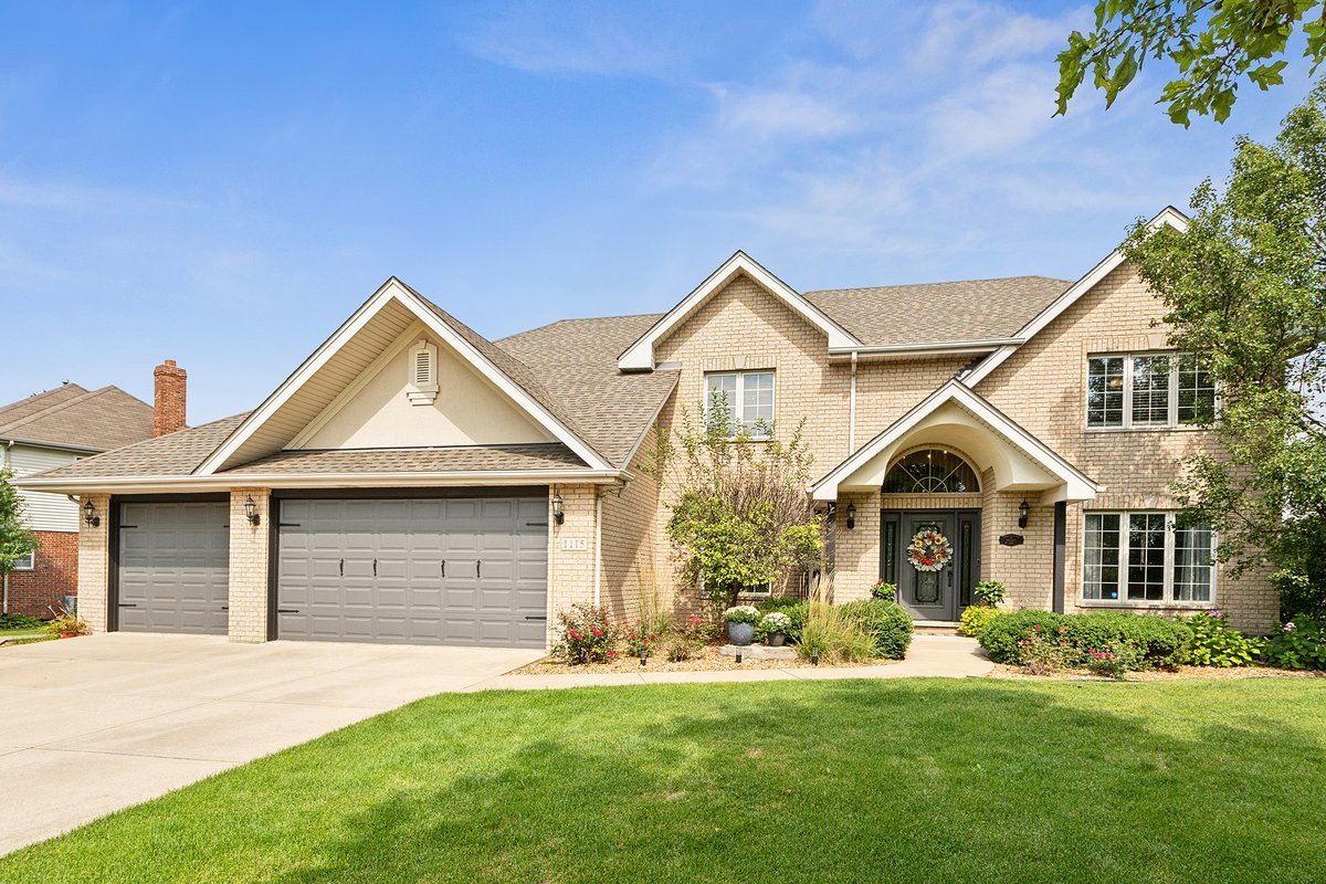 a front view of a house with a garden and yard