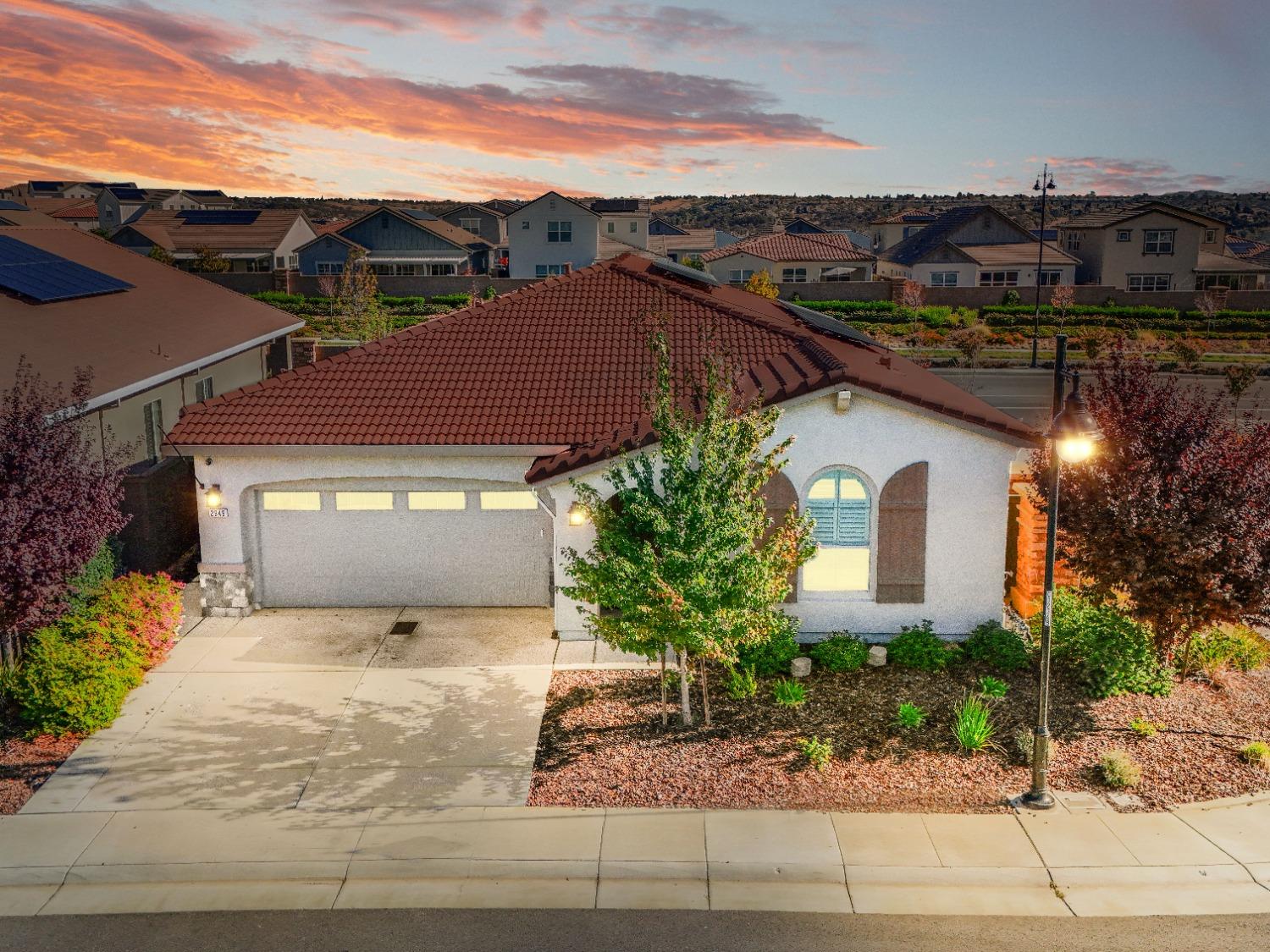 a front view of a house with a yard and mountain view