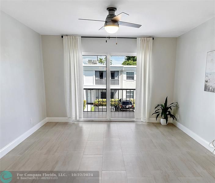 an empty room with wooden floor and a ceiling fan