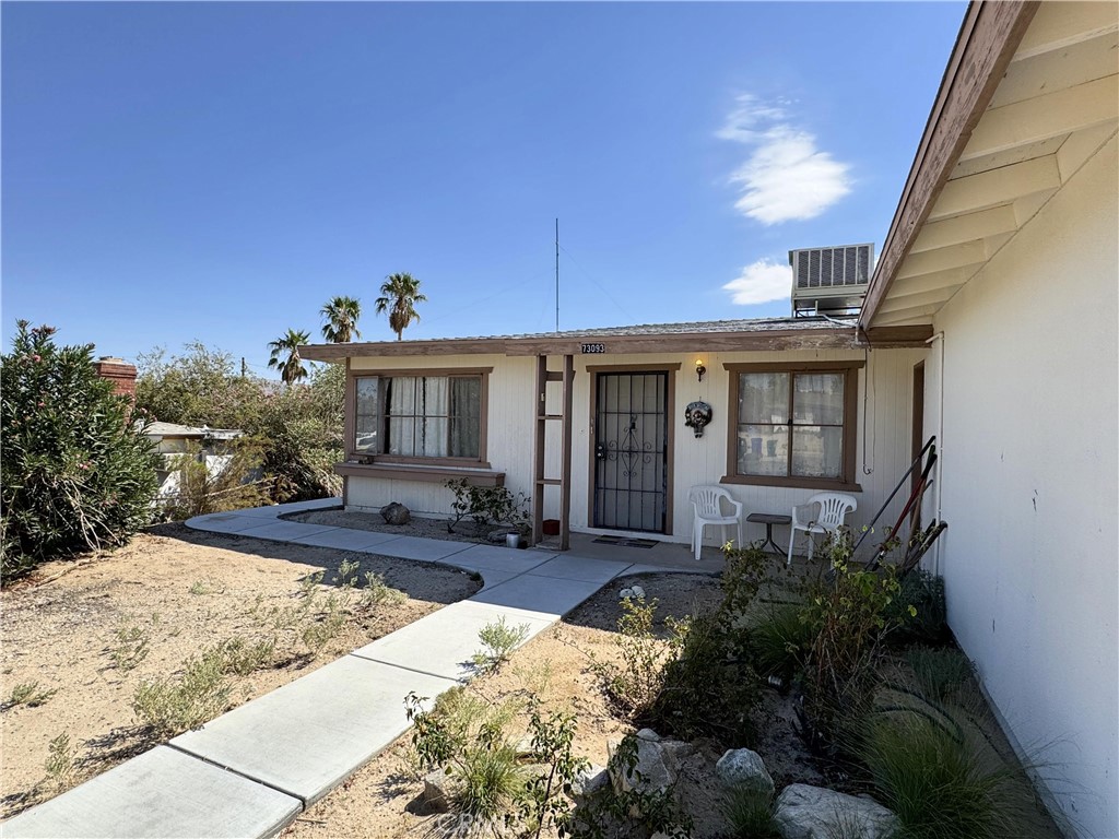 a front view of a house with a yard and potted plants