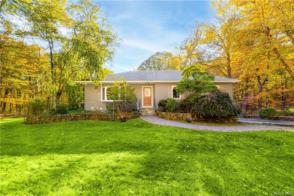 a front view of a house with a garden and trees