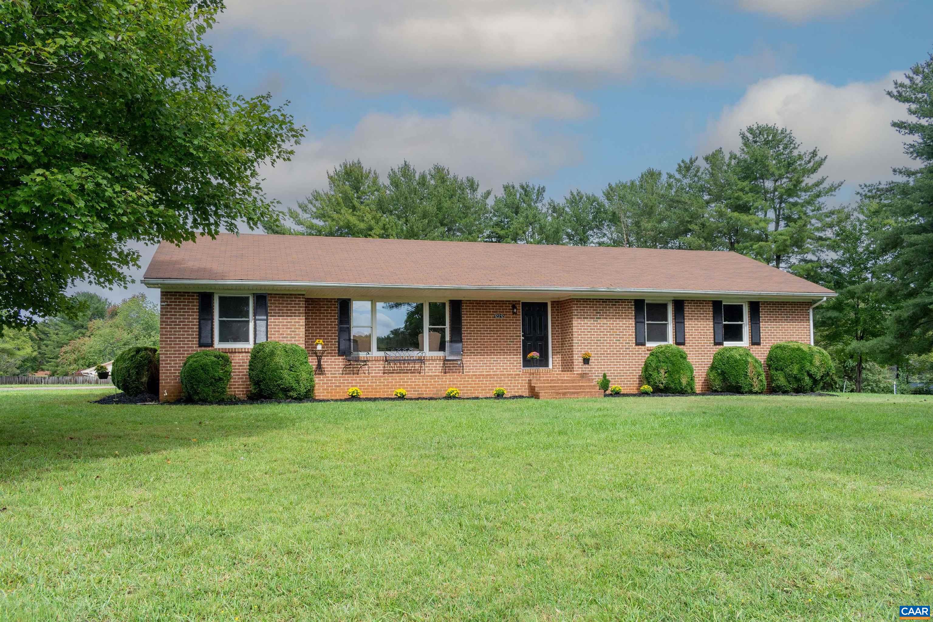 a front view of a house with a yard and trees