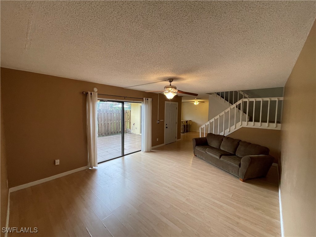 a view of a livingroom with wooden floor and furniture