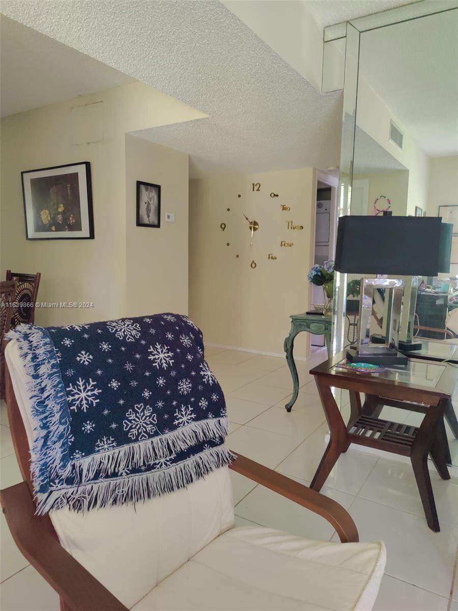 a living room with a couch and a piano next to a window