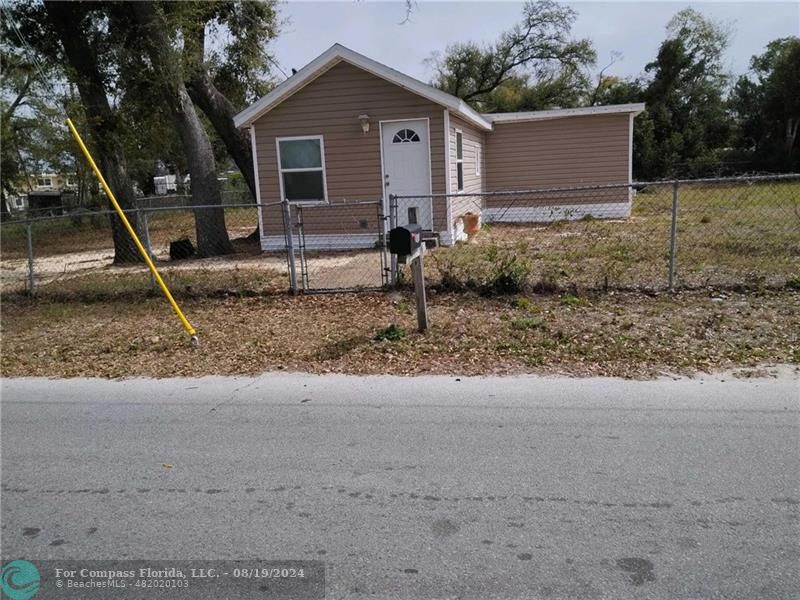 a view of a house with a yard and a tree