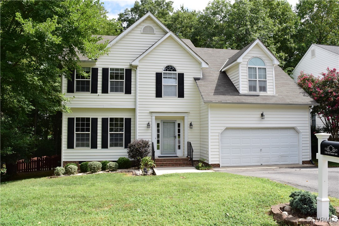 a front view of a house with a yard and garage