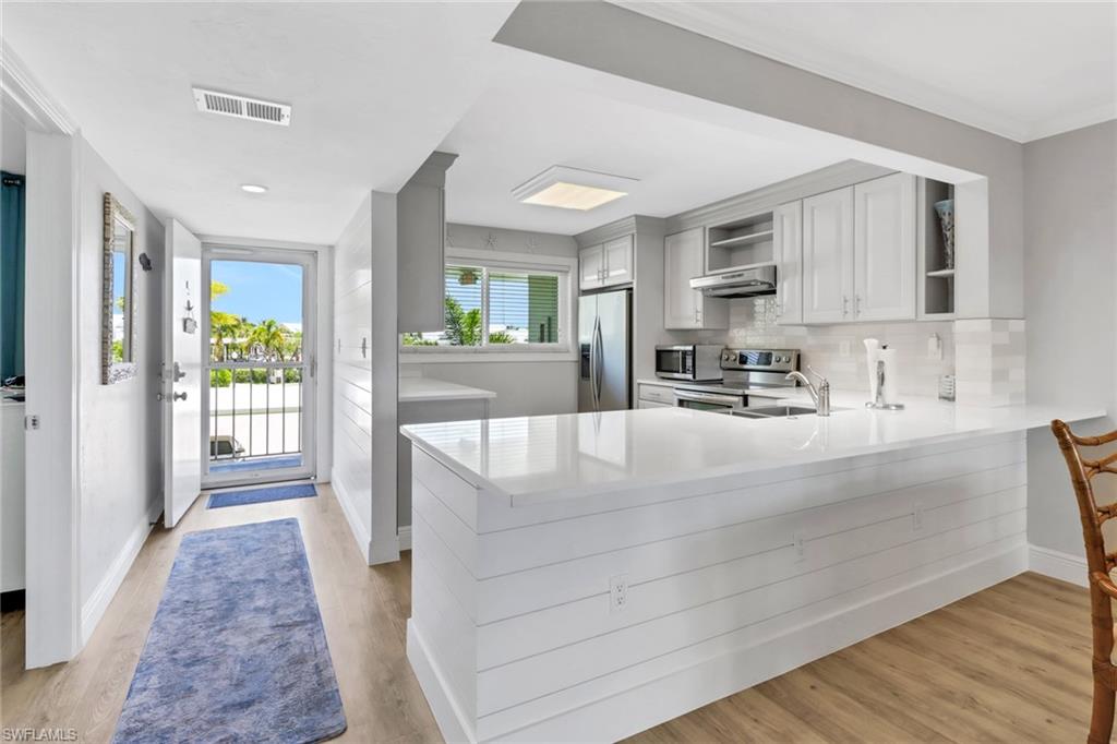 a kitchen with kitchen island a counter top space a sink and appliances