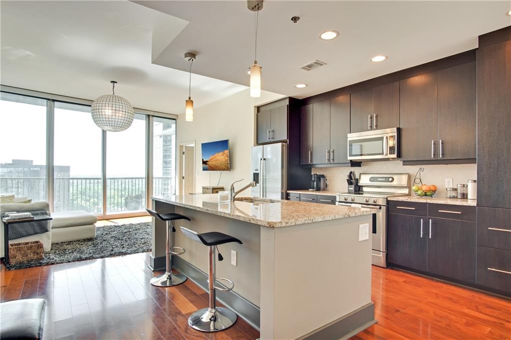 a kitchen with stainless steel appliances granite countertop a sink stove and refrigerator