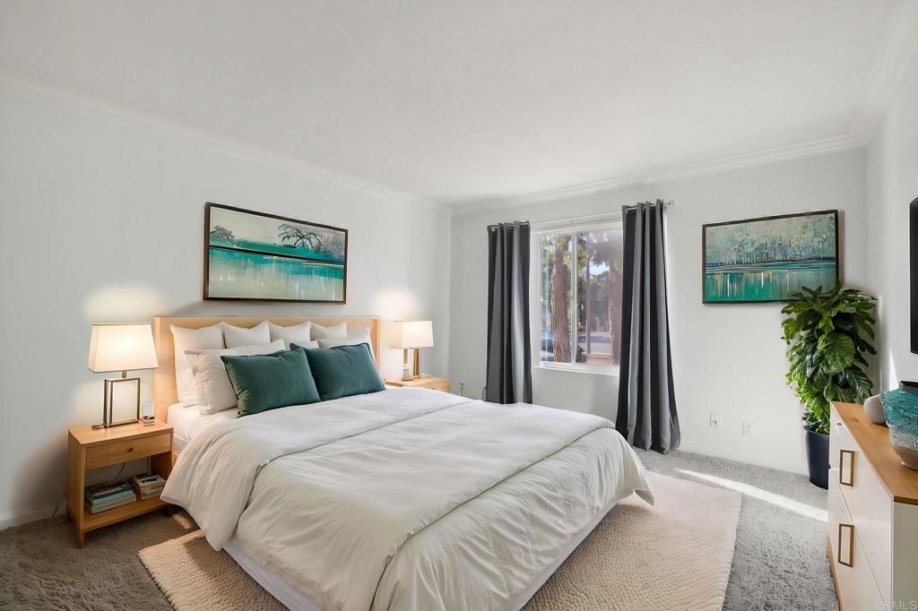 a bedroom with a large bed and a potted plant