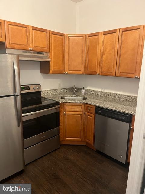 a kitchen with granite countertop wooden cabinets and a stove top oven