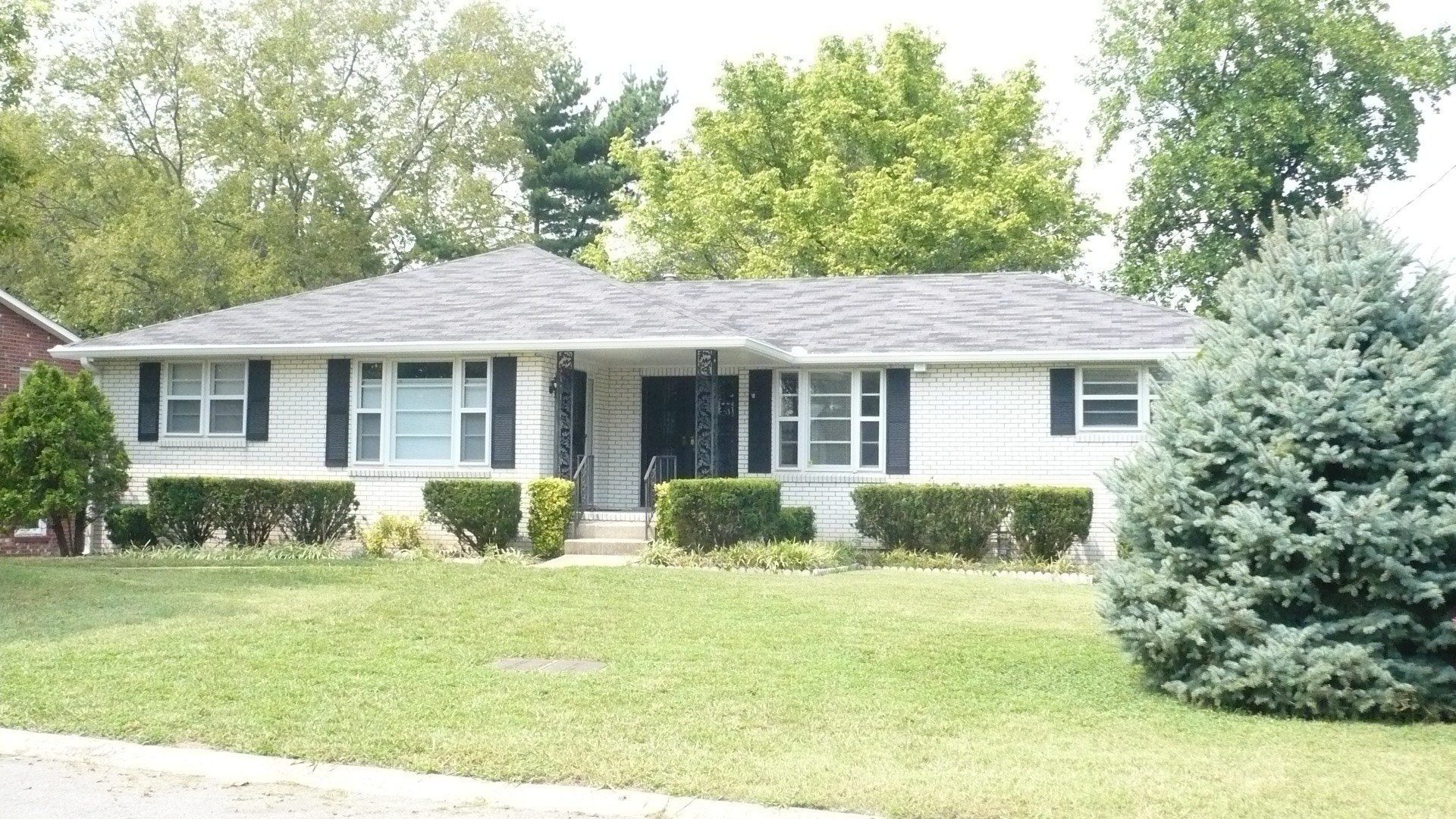 a front view of a house with a yard and outdoor seating