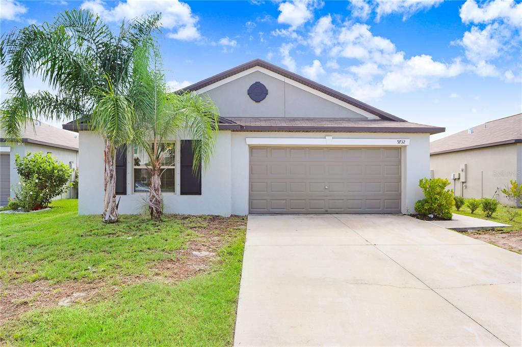 a front view of a house with a yard and garage